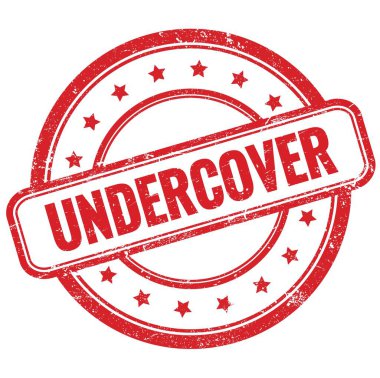 UNDERCOVER 'un kırmızı, eski, pasaklı, yuvarlak, lastik damgalı metni.