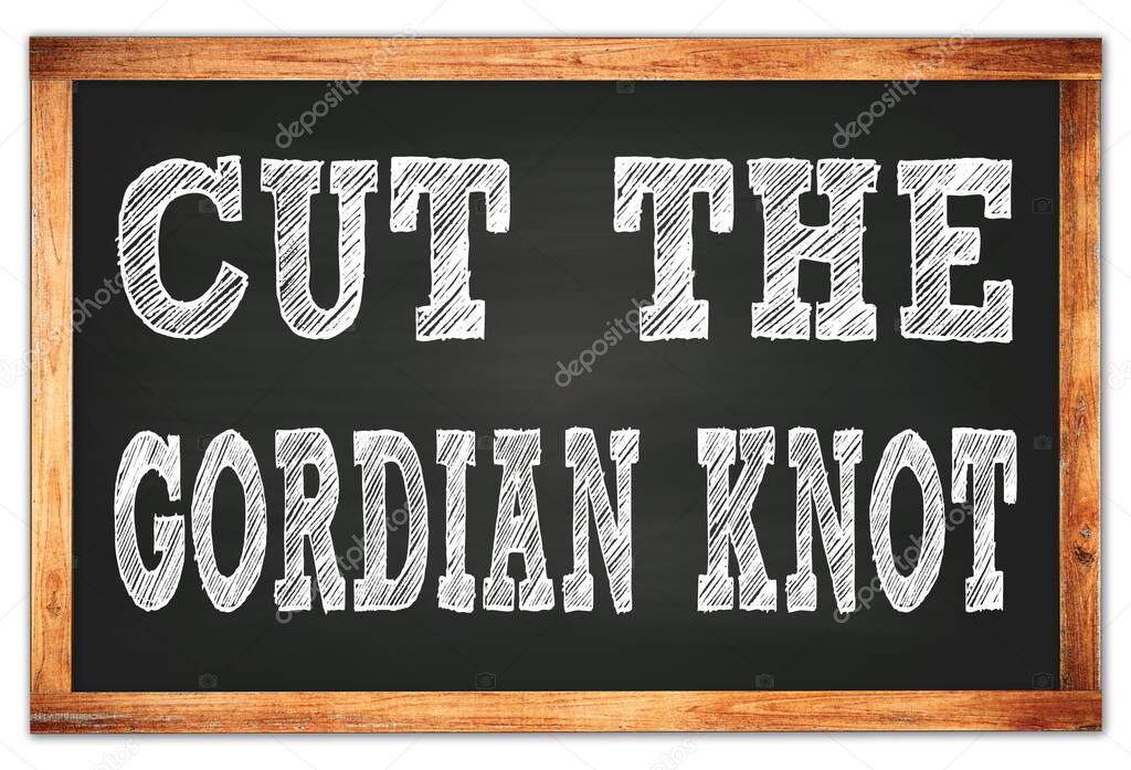 CUT THE GORDIAN KNOT written on black wooden frame school blackboard
