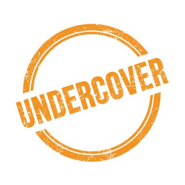 UNDERCOVER metni turuncu grungy vintage yuvarlak damga üzerine yazılmış.