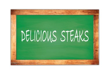 DELICIOUS STEAKS yeşil ahşap çerçeve okul tahtasına yazılmış metin.