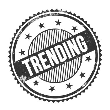 Siyah grungy zig zag kenarları üzerine yazılmış TRENDING metin yuvarlak pul.