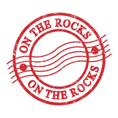 Kayalarda, kırmızı grungy posta pulu üzerine yazılmış metin.