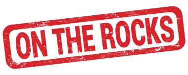 Kayalarda kırmızı dikdörtgen damga işareti üzerine yazılmış metin.