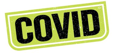 COVID text written on green-black grungy stamp sign.