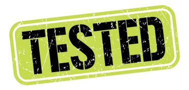 TESTED text written on green-black grungy stamp sign.