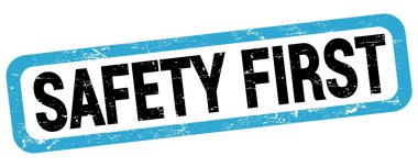 SAFETY FIRST text written on blue-black rectangle stamp sign.