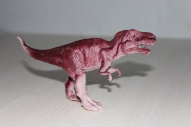 Beyaz zemin üzerinde oyuncak tyrannosaurus