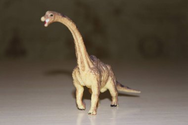 Arka planda Brachiosaurus oyuncak dinozoru