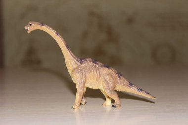Arka planda Brachiosaurus oyuncak dinozoru
