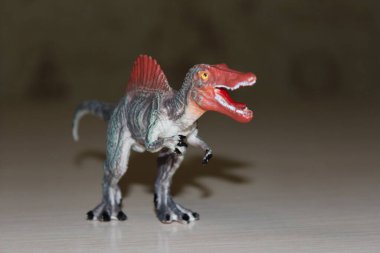 Arka planda Spinosaurus oyuncak dinozoru