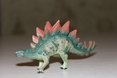 Arka planda Stegosaurus oyuncak dinozoru