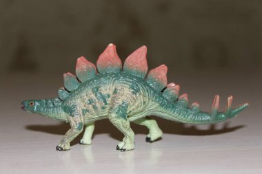 Arka planda Stegosaurus oyuncak dinozoru