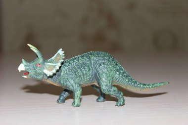 Triceratops arka planda oyuncak dinozor