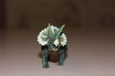 Triceratops arka planda oyuncak dinozor