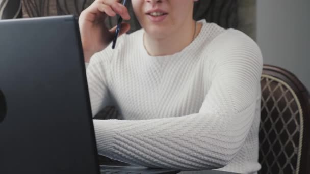 Freelance werknemer werkt met moderne laptop en mobiele telefoon in de kamer. Zakenman, werkend op een laptop, pratend op een smartphone. Mannelijke professionele werken met behulp van een computer en mobiele telefoon in het kantoor, thuis. — Stockvideo