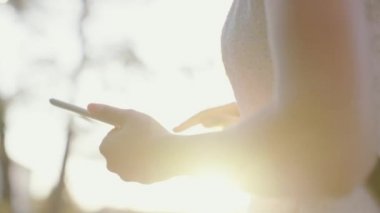 Kızların elleri güneş ışınlarındaki tablete dokunuyor. Şehir caddesinde dijital tablet baskı mesajları kullanan bir iş kadını. Kentte tabletle çalışan serbest çalışan kadın kaldırımda yürüyor.