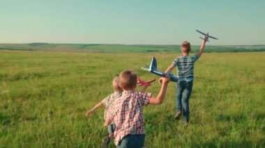 Çocuklar, çocuklar parkta koşar, ellerinde oyuncak uçakla oynarlar, uçmayı hayal ederler. Çocuk oyuncağıyla uçakla oynuyor. Arkadaşlar çocuklar yeşil alan rüya takım çalışması seyahatinde koşar. Mutlu aile hafta sonu