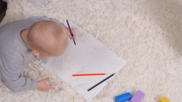 Μια κορούλα ζωγραφίζει με ενθουσιασμό με κίτρινο μολύβι σε χαρτί, ένα κοριτσάκι δίπλα στη μητέρα της. Ευτυχισμένη οικογένεια και παιδί. Μικρέ, ο γιος ζωγραφίζει με χρωματιστά μολύβια, το αγόρι είναι σπίτι με τη μητέρα του. — Αρχείο Βίντεο