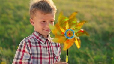 Küçük çocuk gökkuşağı pikabıyla oynuyor, mutlu aile, neşeli çocuk renkli oyuncaklarla fantezi kuruyor, rüzgarın yönünü yakalıyor, oğlu elinde parlak renkli bir çember tutuyor güneş altında parıldıyor.