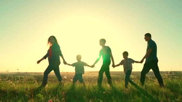 silueta šťastné rodiny při západu slunce, držení malých dětí ručně, dětský sen, děti s rodiči na dovolené, chlapci s otcem a matkou na slunci, láska maminka a tatínek, aktivní procházka