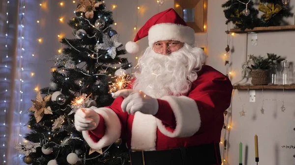 Boldog Mikulás táncol csillagszórókkal, élvezi a zenét. Satna Claus jól érzi magát a szobában a karácsonyfával. Boldog, varázslatos, gyerekes, családi nyaralás, karácsony. Újév, Karácsony — Stock Fotó