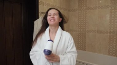 Beyaz bornozlu genç bir kadın saçını kurutuyor, şarkı söylüyor ve evdeki banyoda dans ediyor. Mutlu kadın süper star olmayı hayal ediyor, sanatsal kız evde güzellik tedavisi yapıyor. Şarkı söyle ve eğlen.