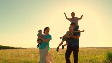 Mutlu aile parkta el ele koşar. Mutlu aile, gün batımında ebeveynlerin ve çocukların siluetini yürütür. Anne, baba ve oğullar dışarıda birlikte yürürler. Doğada aile tatili, çocukların hayalleri ve...