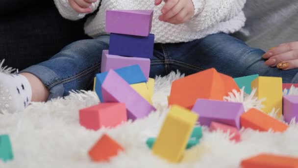 Дочь и мать играют в постройку семейного дома. Мам, ребенок играет с кубиками в детской на полу. Счастливая семья. Образовательные игры для детей. Семейные выходные дома. Обучение ребенка через игру. — стоковое видео