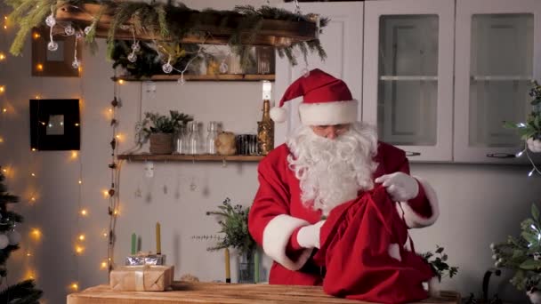 Starý legrační Santa Claus, dává dárkové krabice do tašky. Rodinné oblíbené zimní prázdniny. Vánoční dárky od Santy. Veselé Vánoce. Santaclaus donáška dárků. Slavnostní novoroční nálada. Santa Claus přináší dary — Stock video