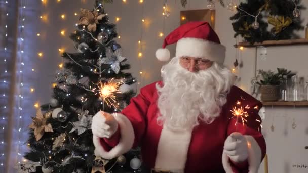 Veselé, kouzelné, děti, rodinná dovolená, Vánoce. Šťastný Santa Claus tancuje s jiskřičkami, užívá si hudbu. Santa Claus se baví na pokoji s vánoční stromeček. Nový rok, Vánoce — Stock video