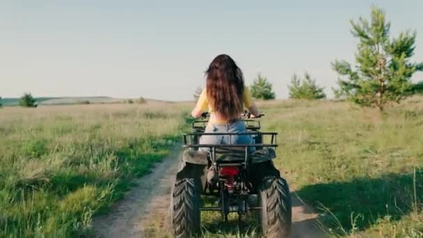 Вільна жінка їде на квадроциклі влітку на брудній дорозі. Позашляховик ATV Adventure. Дівчина веде квадроцикл, пригоди, подорожі, туризм. Відкритий відпочинок влітку навесні, подорожі на відкритому повітрі — стокове відео