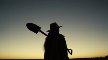 Çiftçinin silueti omuzunda kürek taşır, çiftçilik yapar, toprak toprağıyla tarlada çalışır, damlalık tarlasına gider, gün batımında bahçede bahçıvanlık yapar, tarım ekolojisi doğasında tarım yapar, hasat eder.