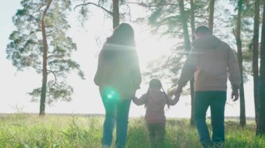 Gün batımında anne ve babayla çocuk, fantastik çocukluk hayali, mutlu aile, küçük çocuk anne ve babasıyla güneşin altında sihirbazlık oynuyor, bir grup insan hayat yolculuğunda, kız çocuğu fanteziler kuruyor.