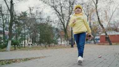 Oyuncak ayı bir çocuğun elinde, sağlıklı bir çocuk. Küçük bir kız, elinde oyuncak ayıyla sonbahar parkında yürüyüş yapan bir çocuk. Çocuk parkında oyuncak ayıyla bebek. Dışarıda oyuncak ayıyla yalnız bir kız