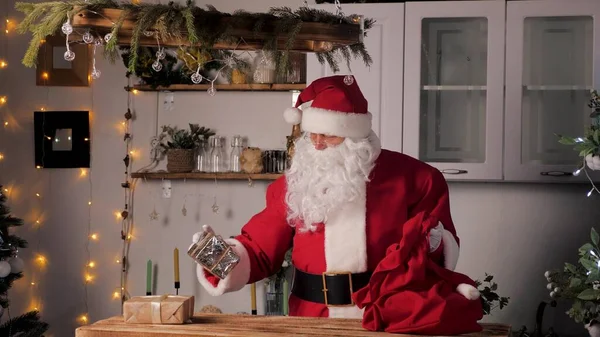 Gamle jultomten lägger presentaskar i en påse. Familjens favorit vintersemester. Julklappar från tomten. God jul. Santaclaus gåva leverans. Festlig nyårskänsla. Jultomten kommer med gåvor — Stockfoto