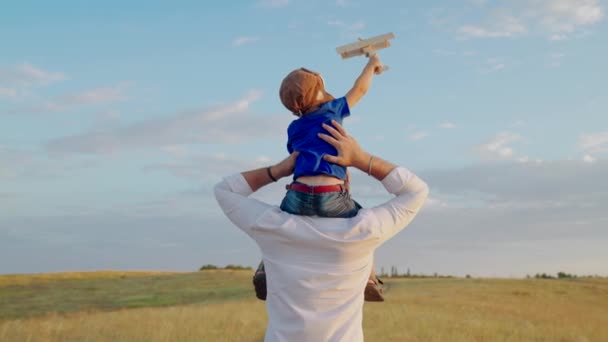 Tata bawi się z małym dzieckiem na ramionach, dziecko marzy o byciu pilotem samolotu. Szczęśliwa rodzina. Mały syn z tatą, wycieczka weekendowa z dzieckiem, dzień ojców. Tatuś i syn koncepcja gry — Wideo stockowe