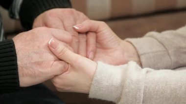 Genç bir kadın yaşlı bir adamın elini tutuyor. Yetişkin bir kadının, kızının, torununun avuç içleri yaşlı bir babanın, büyükbabanın bir erkeğin elini tutuyor. Aşk bakımı, yaşlı ebeveynlere yardım