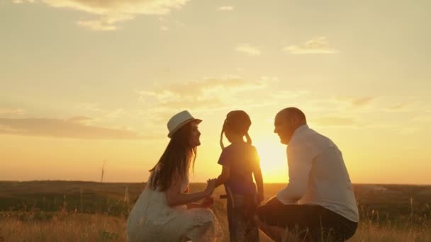 Küçük oğlum, çocuk anne ve babasıyla birlikte yazın gün batımında parkta oynuyor. Aile gezisi, baba oğul, anne manzara ve güneşe hayran. Aile değerleri, ebeveynler ve çocuklar birlikte yürür. Mutlu aile, çocukluk — Stok video