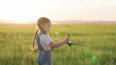 Mutlu çocuk, yaz sahasında oyuncak uçakla oynayan kız. Çocuk oyuncak uçakla çimenlerde oynuyor. Park 'taki mutlu aile. Kızım, çocuk uçmayı hayal ediyor. Kaygısız çocuk baharda yeşil çimlerde oynuyor.