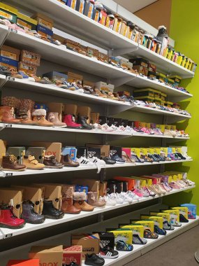 Hoogstraten, Belçika - 2 Ekim 2021: Belçika 'da bir ayakkabı mağazasında her beden, renk ve marka çocuk ayakkabısı dolu bir rafın portresi.