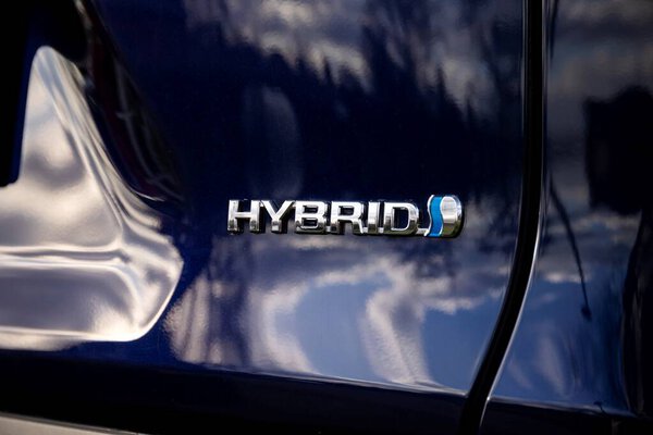 Брехт, Бельгия - 5 февраля 2022: Гибридный логотип на синем автомобиле, показывающий, что автомобиль имеет гибридные технологии внутри и будет использовать топливо, но также проедет некоторое расстояние на электрической энергии.