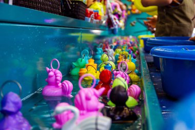 Eğlence fuarındaki ördek oyunu nehrinin portresi. Belçika 'da, oyuncak ördekleri yakalayıp tezgahtan ödül seçebilen küçük çocuklar için yapılan yaygın bir oyundur..