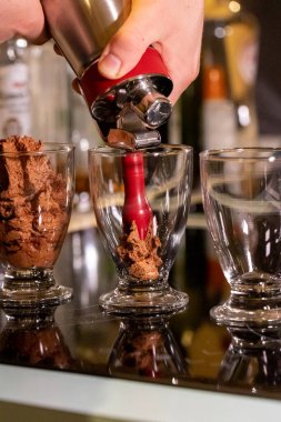 Cam bardaklara çikolatalı mus püskürten birinin portresi espuma cihazını kullanarak daha havadar yapıyor. Lezzetli tatlı kahverengi, lezzetli ve yemeye hazır..