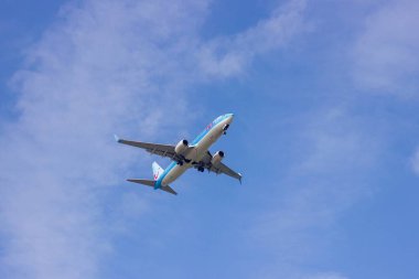 Middlekerke, Belgium - july 23 2022: a commercial airplane flying low with its landing gear out. The airline plane has its wheels out and is transporting tourists and is ready to land at the airfield.