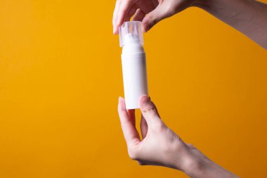 Kadın ellerinde losyon ya da el kremi paketi