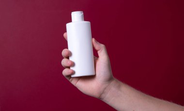 Elinde losyon şişesi tutan bir adam.