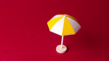 Kırmızı arkaplanda renkli plaj şemsiyesi