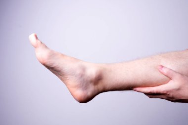 Gri arka planda yalıtılmış erkek bacak
