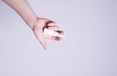 Erkek el burun spreyi tutuyor.