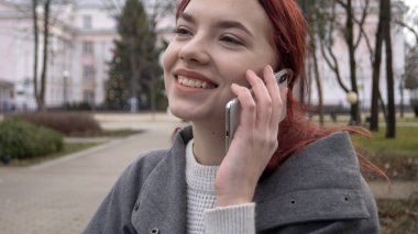 Terasta telefonlu bir kadın var.